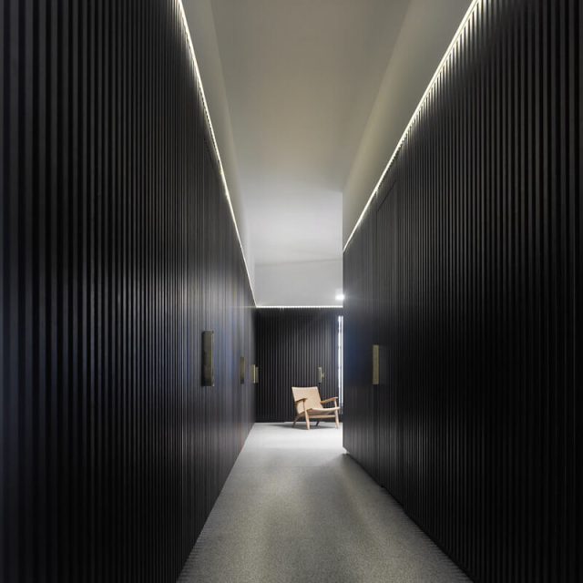pasillo largo con paneles de madera oscura a los lados